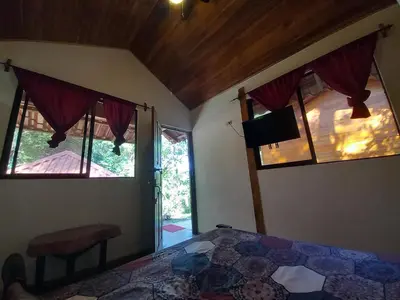 a bedroom with a bed and two windows in a room at Aura Bungalow 2 in Tamarindo