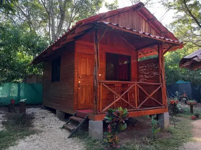 a small wooden house with a red roof at Aura Bungalow 2 in Tamarindo