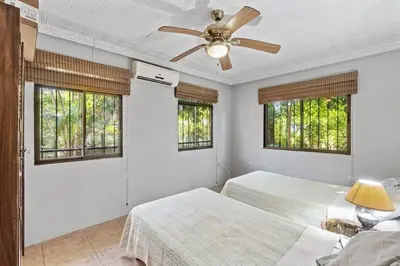 a bedroom with two beds and a ceiling fan at 2-Bedroom House with Pool in Playa Flamingo