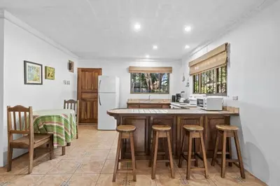 a kitchen with a counter and some stools in it at 2-Bedroom House with Pool in Playa Flamingo
