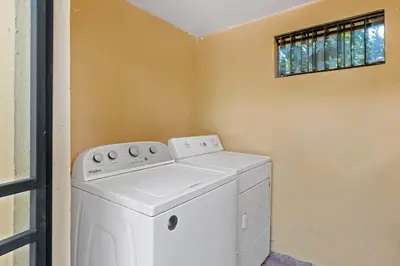 a washing machine in a laundry room with a window at 2-Bedroom House with Pool in Playa Flamingo