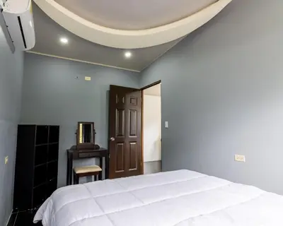 a bedroom with a white bed and a ceiling at Villa el Descanso in San Pedro