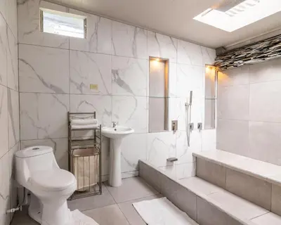a white bathroom with a toilet and a sink at Villa el Descanso in San Pedro