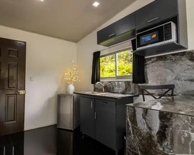 a kitchen with a sink and a microwave at Villa el Descanso in San Pedro