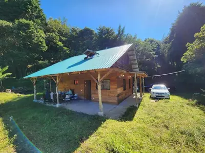 a log cabin with a dog on the roof at Cabaña Trojas Valverde Vega in Trojas