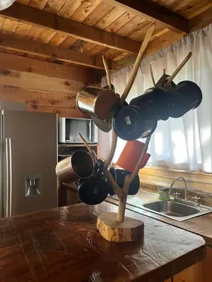 a bunch of pots and pans hanging on a kitchen counter at Cabaña Trojas Valverde Vega in Trojas