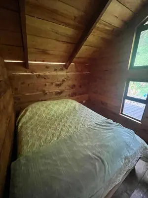 a bedroom with a bed in a wooden cabin at Cabaña Trojas Valverde Vega in Trojas