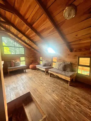 a large room with couches and windows in a cabin at Cabaña Trojas Valverde Vega in Trojas