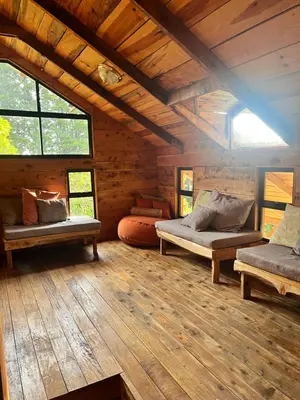 a room with two beds in a log cabin at Cabaña Trojas Valverde Vega in Trojas