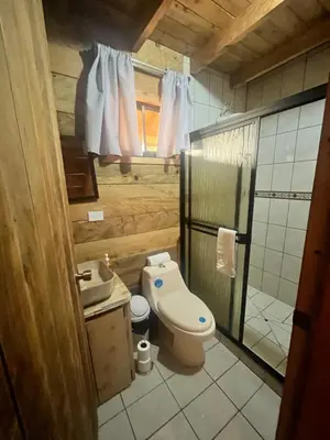 a small bathroom with a toilet and a sink at Cabaña Trojas Valverde Vega in Trojas