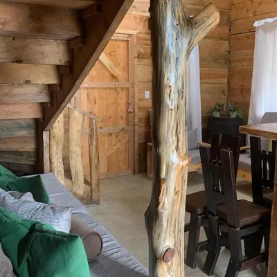 a room with a table and a tree in a cabin at Cabaña Trojas Valverde Vega in Trojas