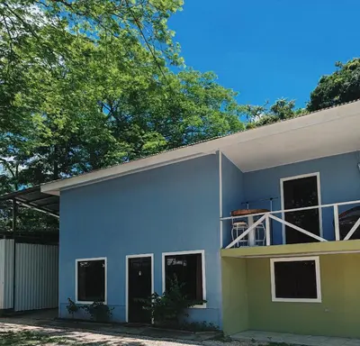a blue house with a balcony on the side of it at Casa Hortensia in Nicoya