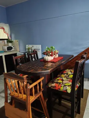 a dining room table with chairs and a bowl of flowers at Casa Hortensia in Nicoya