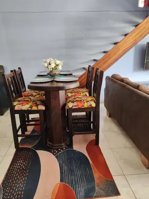 a dining room with a table with chairs and a couch at Casa Hortensia in Nicoya