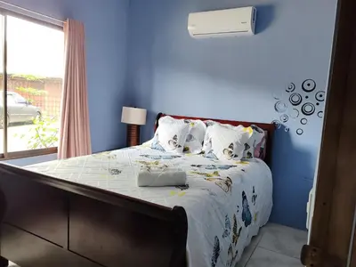 a bedroom with a bed with blue walls and a window at Casa Hortensia in Nicoya
