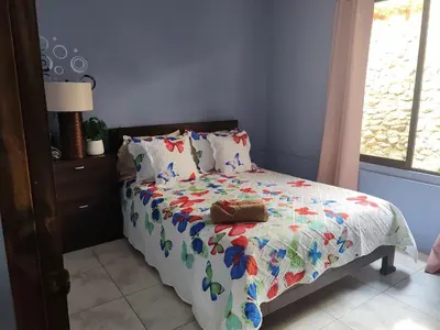 a bedroom with a bed with a colorful comforter at Casa Hortensia in Nicoya