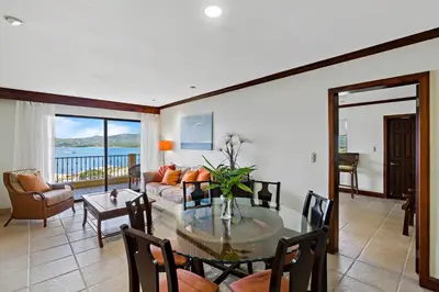 a living room with a table and a couch at Remodeled Top-Floor Condo with Stunning Wrap-Around Balcony Offering Mountain, Ocean & Marina Views in Playa Flamingo