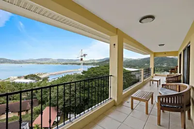 a balcony with a view of the ocean at Remodeled Top-Floor Condo with Stunning Wrap-Around Balcony Offering Mountain, Ocean & Marina Views in Playa Flamingo