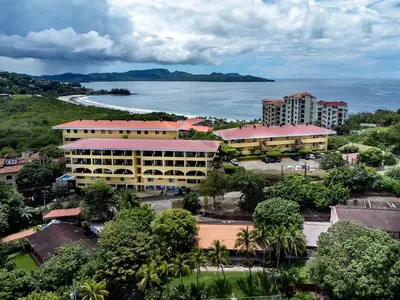 an aerial view of a resort and the ocean at Remodeled Top-Floor Condo with Stunning Wrap-Around Balcony Offering Mountain, Ocean & Marina Views in Playa Flamingo