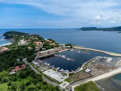 an aerial view of a harbor with boats in the water at Remodeled Top-Floor Condo with Stunning Wrap-Around Balcony Offering Mountain, Ocean & Marina Views in Playa Flamingo