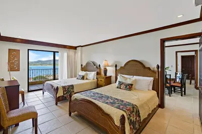 a hotel room with two beds and a balcony at Remodeled Top-Floor Condo with Stunning Wrap-Around Balcony Offering Mountain, Ocean & Marina Views in Playa Flamingo