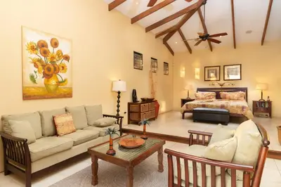 a living room with a couch and a bed at Oceanview Villa with Wrap-Around Terrace, Private Pool, Hot Tub, and Guesthouse in Playa Flamingo