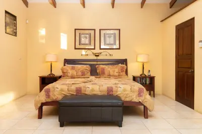 a bedroom with a bed and two lamps and two tables at Oceanview Villa with Wrap-Around Terrace, Private Pool, Hot Tub, and Guesthouse in Playa Flamingo