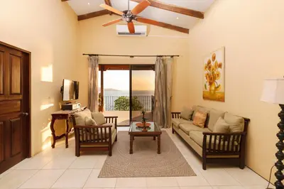 a living room with a couch and a ceiling fan at Oceanview Villa with Wrap-Around Terrace, Private Pool, Hot Tub, and Guesthouse in Playa Flamingo