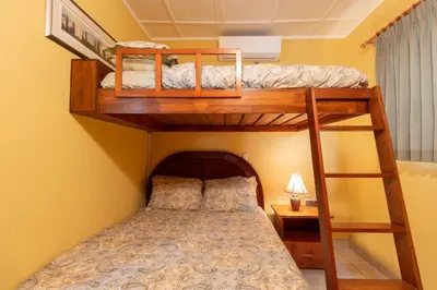 a bedroom with two bunk beds and a bed at Oceanview Villa with Wrap-Around Terrace, Private Pool, Hot Tub, and Guesthouse in Playa Flamingo