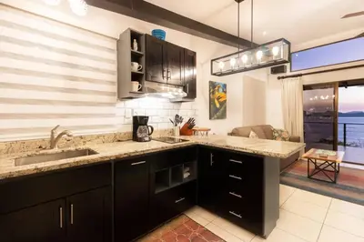 a kitchen with a sink and a counter top at Modern Studio Apartment with Covered Balcony, Full Kitchen, and Stunning Ocean Views in Playa Flamingo