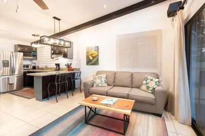 a living room with a couch and a table at Modern Studio Apartment with Covered Balcony, Full Kitchen, and Stunning Ocean Views in Playa Flamingo