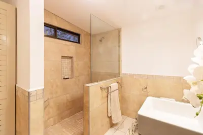 a bathroom with a shower and a white sink at Modern Studio Apartment with Covered Balcony, Full Kitchen, and Stunning Ocean Views in Playa Flamingo