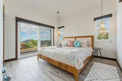 a bedroom with a bed and a large window at Beautiful House with Sweeping Ocean Views, Modern Design, and a Private Infinity Pool in Potrero