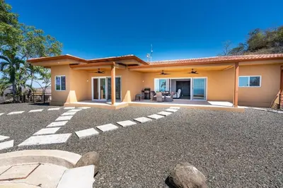 a house with a gravel driveway in front of it at Beautiful House with Sweeping Ocean Views, Modern Design, and a Private Infinity Pool in Potrero