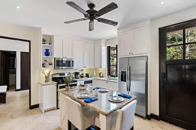 a kitchen with a table and a ceiling fan at Stylish Beach-Themed Condo with Two Bedrooms and Lovely Ocean Views in Playa Danta