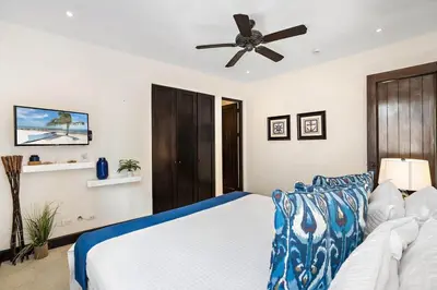 a bedroom with a bed and a ceiling fan at Stylish Beach-Themed Condo with Two Bedrooms and Lovely Ocean Views in Playa Danta