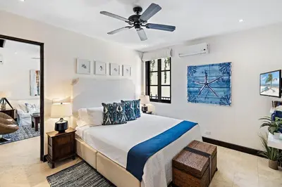 a bedroom with a bed and a ceiling fan at Stylish Beach-Themed Condo with Two Bedrooms and Lovely Ocean Views in Playa Danta