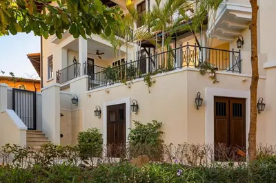a white house with balconies and trees at Beautiful Mediterranean-Style Penthouse with an Oceanview Balcony in Playa Danta