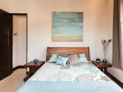 a bedroom with a bed and a painting on the wall at Beautiful Mediterranean-Style Penthouse with an Oceanview Balcony in Playa Danta