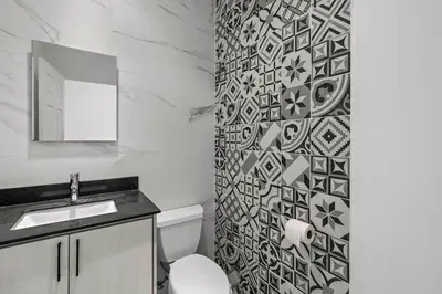 a bathroom with a toilet and a sink and a mirror at Stunning Top-Floor Condo with Sweeping Ocean & Mountain Views & Beach Club in Coco