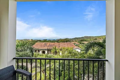 a balcony with a view of a house at Stunning Top-Floor Condo with Sweeping Ocean & Mountain Views & Beach Club in Coco
