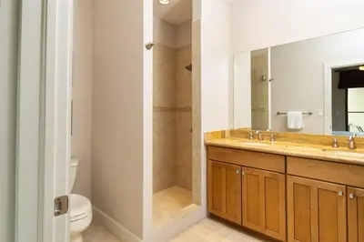 a bathroom with a sink and a toilet and a mirror at 3-Bedroom 2-Bath Condo Overlooking Pool in Coco