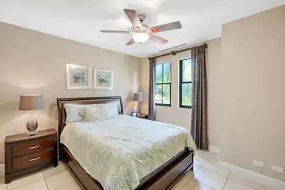 a bedroom with a bed and a ceiling fan at Luxe 3-BD Condo on 2nd Floor Above Pool in Coco
