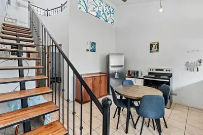 a kitchen with a table and chairs and a stove at Bright and Spacious Loft-Style Apartment a Five-Minute Walk to the Beach in Coco
