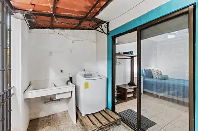 a bathroom with a sink and a refrigerator in a room at Bright and Spacious Loft-Style Apartment a Five-Minute Walk to the Beach in Coco