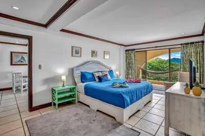 a bedroom with a bed and a large window at Newly remodeled unit in Flamingo with sweeping ocean views from big terrace in Playa Flamingo