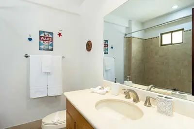 a bathroom with a sink and a toilet and a mirror at Newly remodeled unit in Flamingo with sweeping ocean views from big terrace in Playa Flamingo
