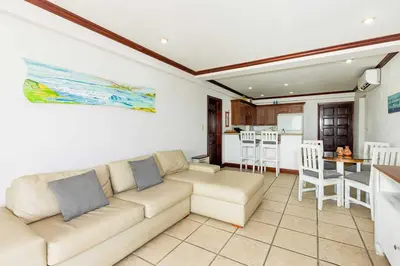 a living room with a couch and a kitchen at Newly remodeled unit in Flamingo with sweeping ocean views from big terrace in Playa Flamingo