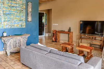 a living room with a couch and a tv at Jungle Jewel in Quepos