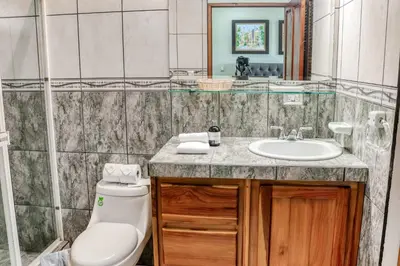 a bathroom with a toilet and a sink at Jungle Jewel in Quepos